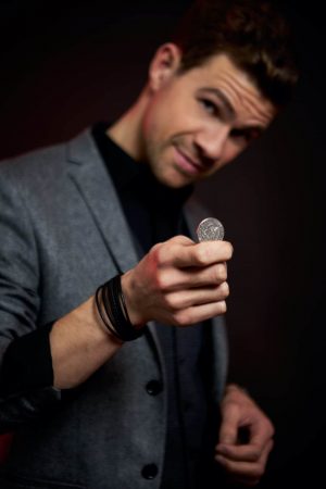 Zauberkünstler Düsseldorf Dominik Fontes mit einer Münze am zaubern